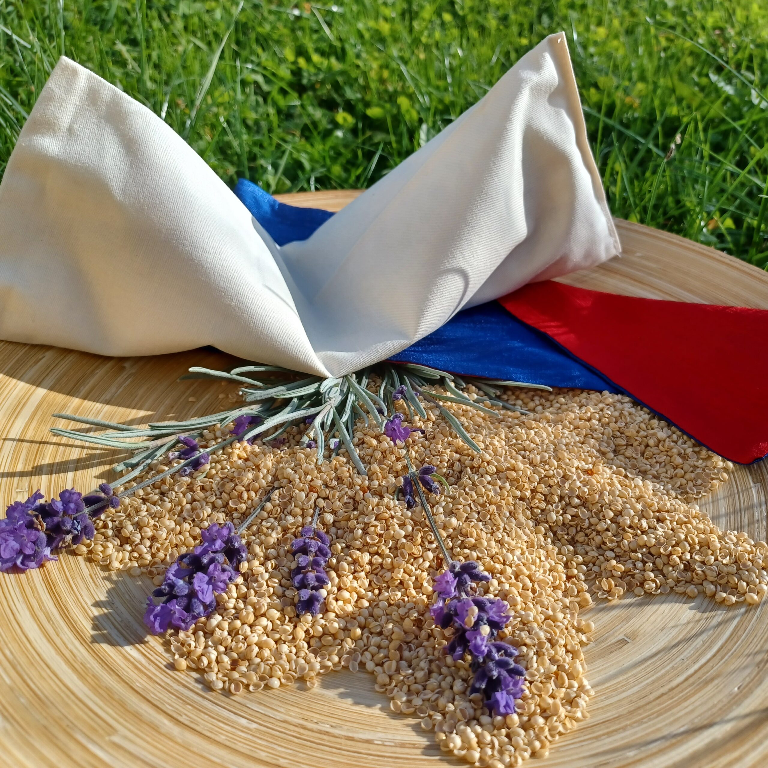 Zusehen sind ein beiges Augenkissen was auf einen kleinen Arrangement aus gewaschener Hirsespelz mit 4 kleinen Lavendelzweigen.
