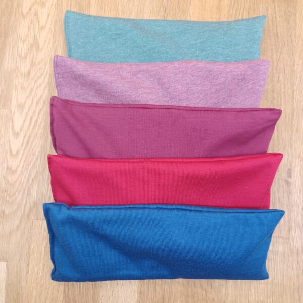 Zusehen sind 5 Augenkissen je in den Farben hellgrün-meliert, rose-meliert, weinrot, kirschrot und royalblau.