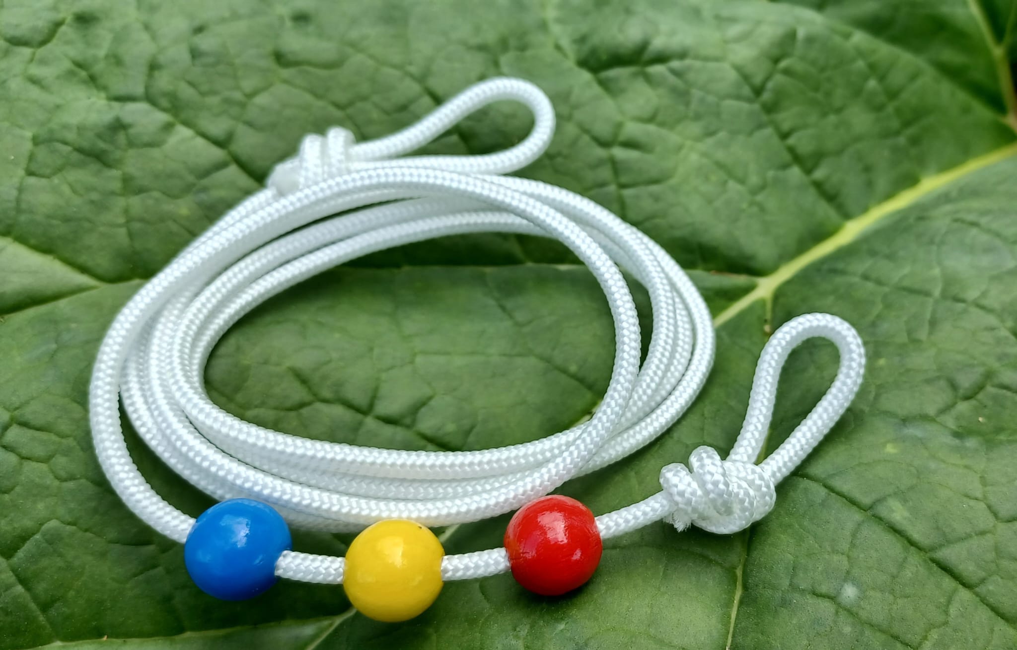 Diese Perlenschnur für Augenübungen im Sehtraining heißt Brockschnur. Sie erhalten sie bei www.sehgut.de mit 3 oder 4 verschiebbaren Perlen in den Farben rot, grün, blau und gelb.